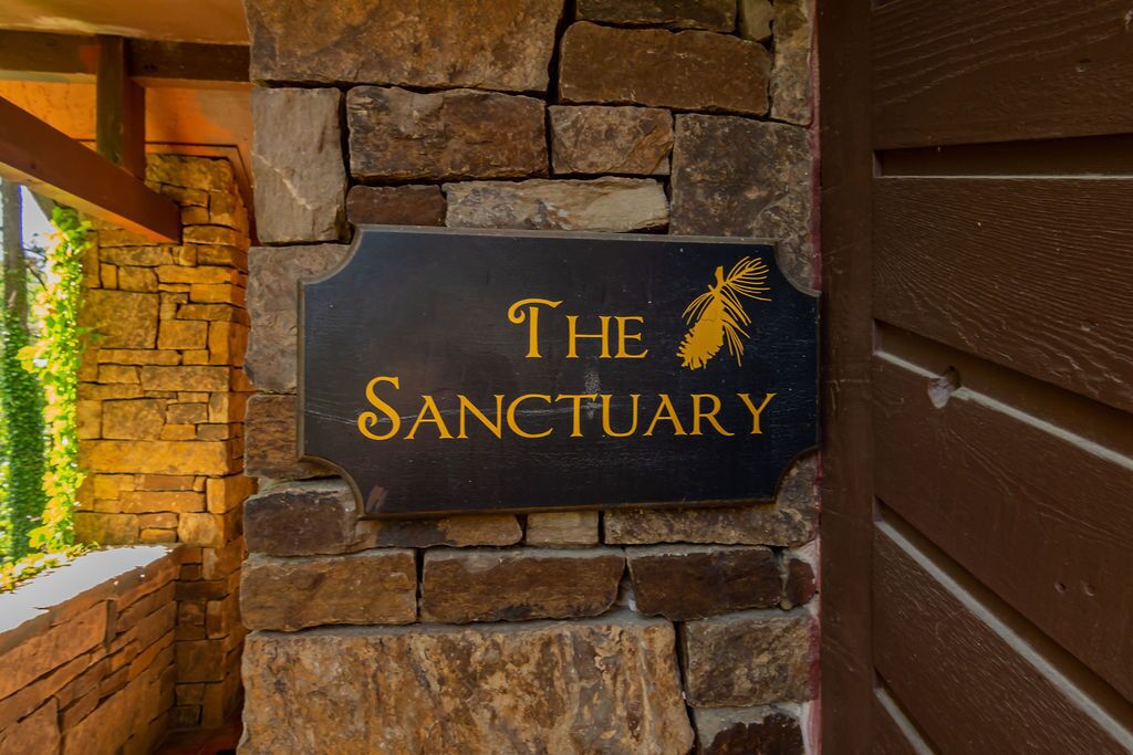 A sign reading "The Sanctuary" mounted on a stone wall.