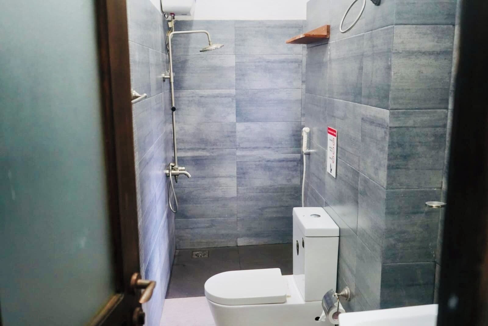 A small bathroom with a shower, toilet, and sink.