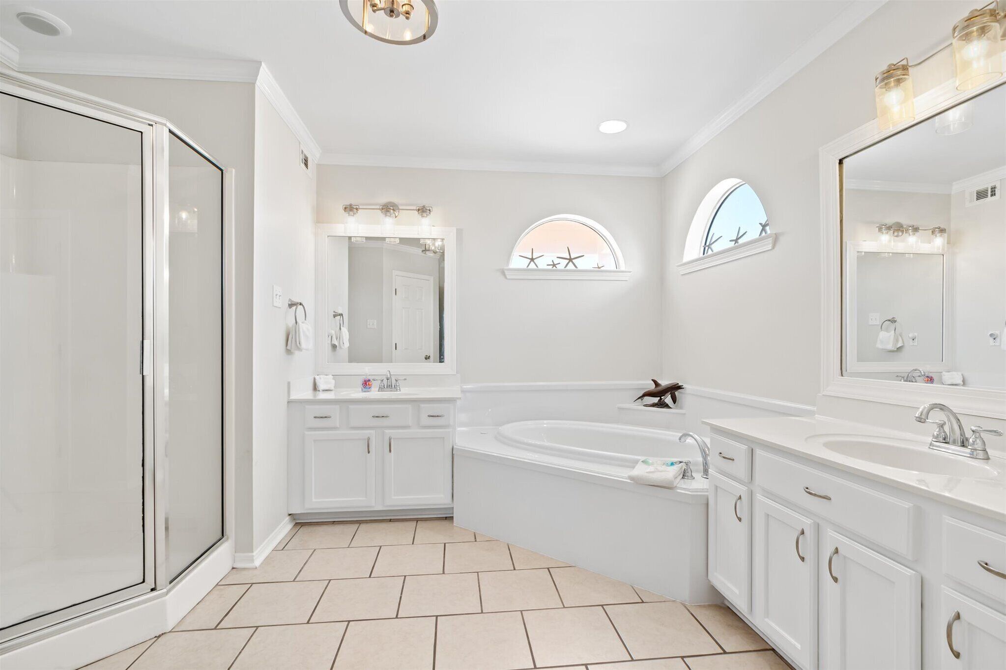 Une salle de bain moderne dotée d’une douche à l’italienne, d’une baignoire sur pieds et d’un meuble-lavabo avec un grand miroir.