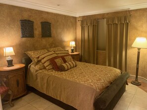 A bedroom with a large bed, two nightstands with lamps, a wooden cabinet, and a floor lamp. - Spacious, Comfortable 2 Master Bedroom Condo - outstanding location!! (Las Vegas)