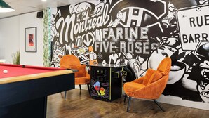 A pool table, two orange chairs, and a mural with text and graphics. - MTLVR #09 | Central Plateau, A/C, Ping-Pong (Montreal)