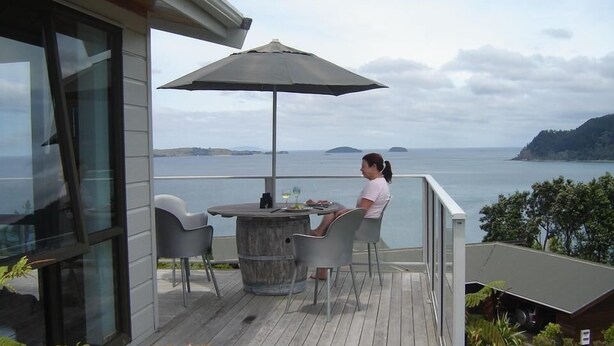 A balcony with a table and chairs, overlooking a body of water and distant land. - Paku Paradise, Tairua. (Tairua)