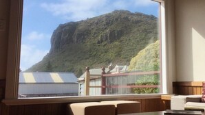 A restaurant with a large window offering a view of a mountain. - The Lodge of Stanley (Stanley)
