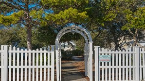 A gated entrance with a sign indicating parking for pool patrons only, no overnight parking.