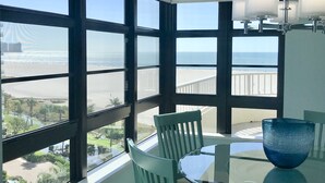 Ein Zimmer mit großen Fenstern und Blick auf Strand und Meer.