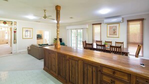 A spacious kitchen with a central island, wooden cabinets, and a ceiling fan. - Wandew - Echuca Holiday Homes (Echuca)
