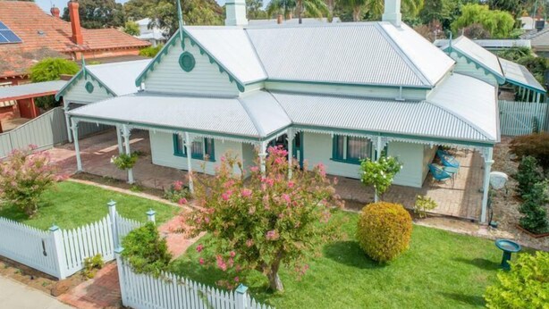 A two-story house with a gabled roof, a porch, and a fenced yard. - Wandew - Echuca Holiday Homes (Echuca)