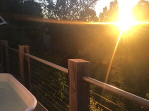 A balcony with a wooden railing overlooking a garden.