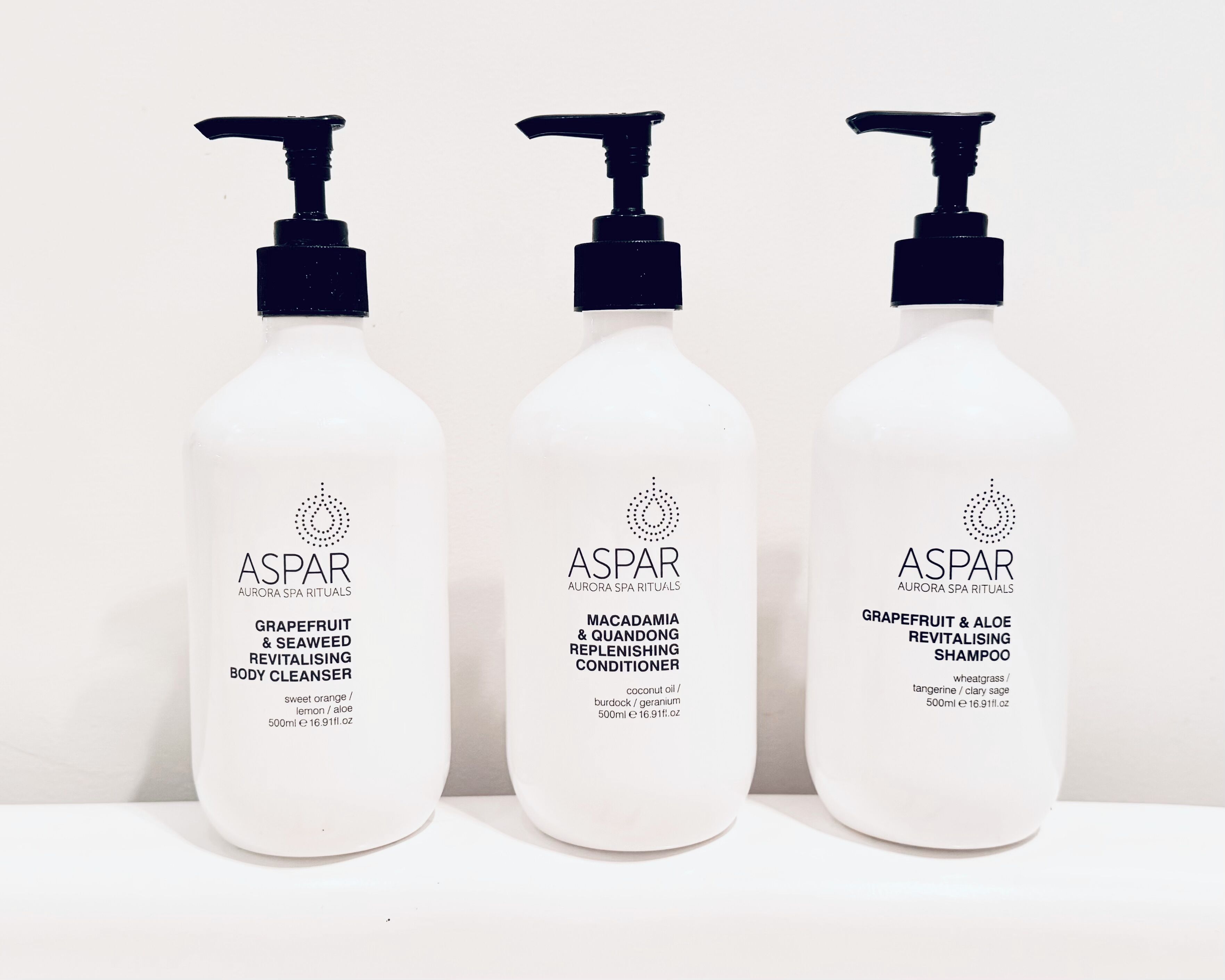 Trois flacons de produits de soins corporels de la marque ASPAR.