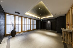A spacious lobby with large windows, a modern ceiling design, and a reception desk.