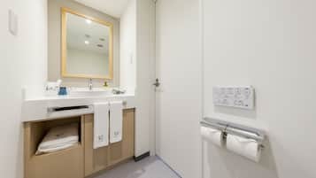 A modern bathroom with a sink, mirror, towel racks, and a toilet paper holder.