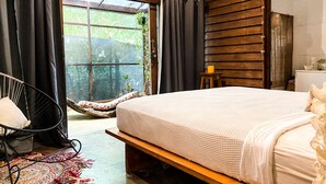 A bedroom with a bed, a chair, a small table, and a window with curtains. - Las Avellanas Villas Costa Rica - Full equipped house(max 2p) (Santa Cruz)
