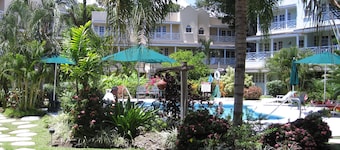 Beautiful Condo with breezy Balcony Overlooking Pool & Garden – Steps to Beach