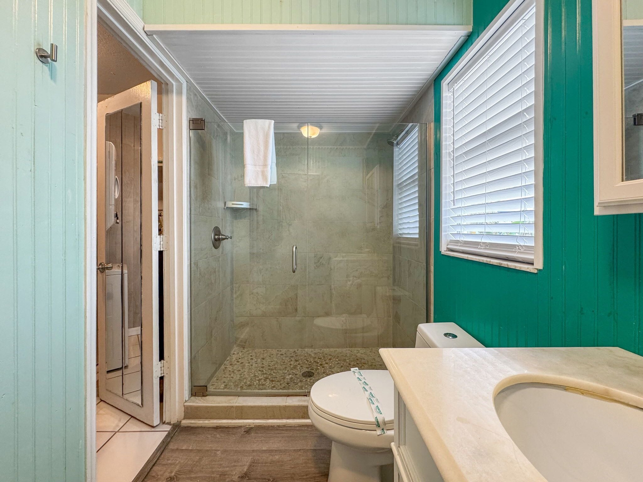A bathroom with a shower, toilet, and sink.