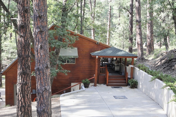 Surrounded by mature trees, the cottage has a designated parking spot.