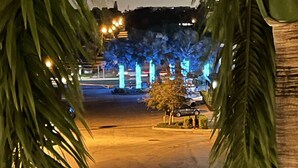 A nighttime view of a parking area with palm trees and illuminated columns. - South Florida's Intercoastal Waterway (Pompano Beach)