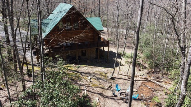 A log cabin with a green roof, surrounded by a forest. - Business wifi, privacy, luxury, creek, firepit, theater, comfort and unique
(Pigeon Forge)
