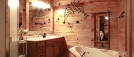 A wooden cabin bathroom with a large sink, vanity, and bathtub.