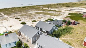 A coastal residential area with houses, a beach, and a view of the sea.