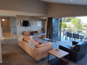 A modern living room with a sofa, a coffee table, and a TV mounted on the wall.