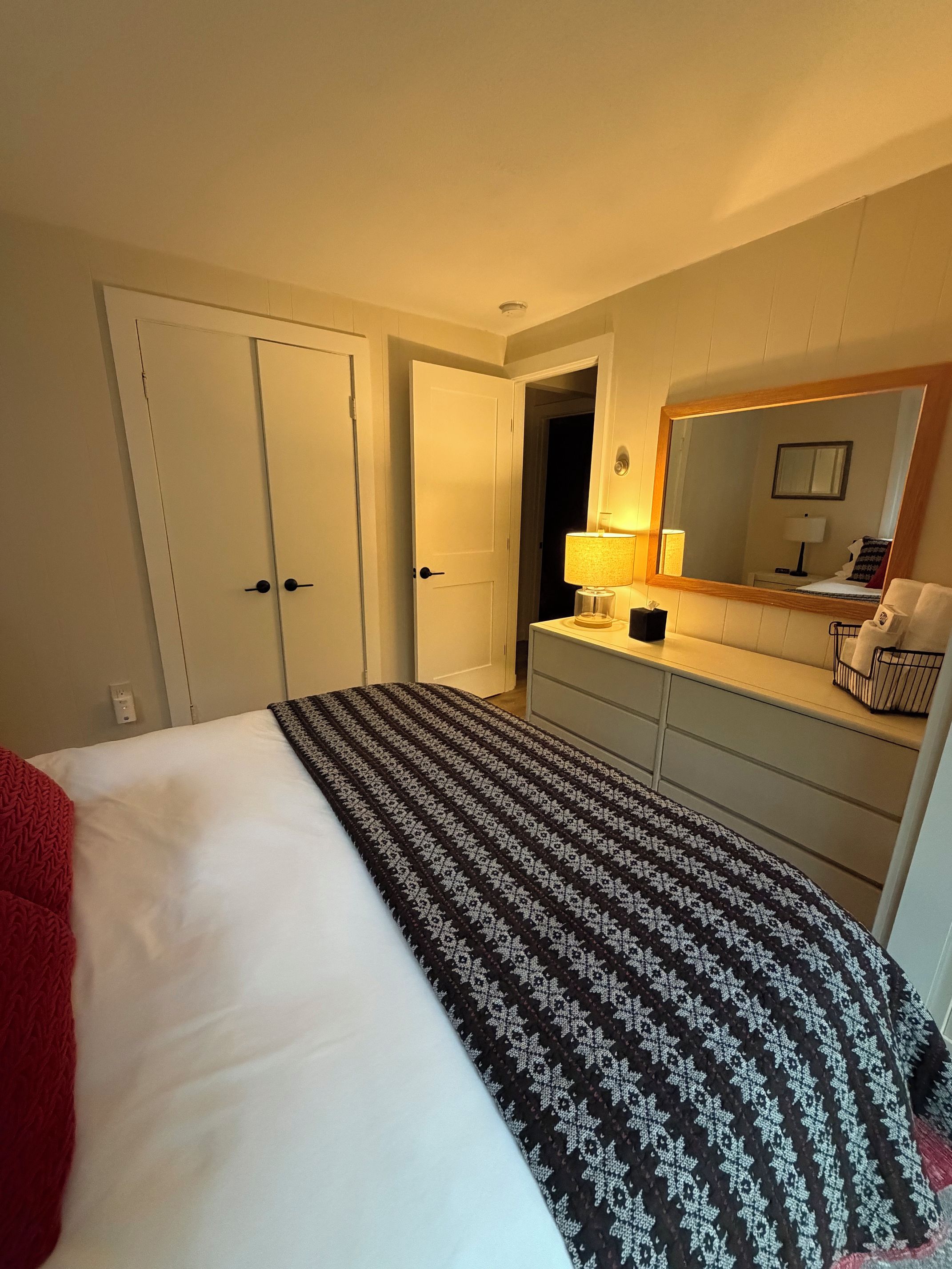 Ein Hotelzimmer mit einem Bett, einem Schminktisch, einem Spiegel und einer Lampe.