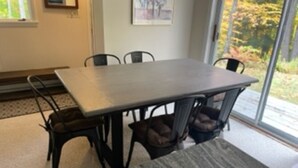 A dining area with a rectangular table and six chairs. - Ski On, Ski off Okemo Trailside Appartment, Sleeps 6/ $550per night, (Ludlow)