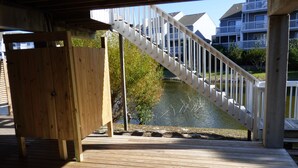 A wooden deck with a white staircase leading to a balcony overlooking a body of water. - Pet-Friendly Beach Retreat Near Pool/Pickle Ball Courts With Weekly Discounts! (Port St Joe)