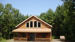 A wooden cabin with a porch and two windows. - Log Cabin-Unique/Beautiful (Candor)