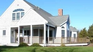 A white two-story house with a porch and a chimney. - Chatham-Walk to Town/Beach-Multi Family Friendly (Chatham)