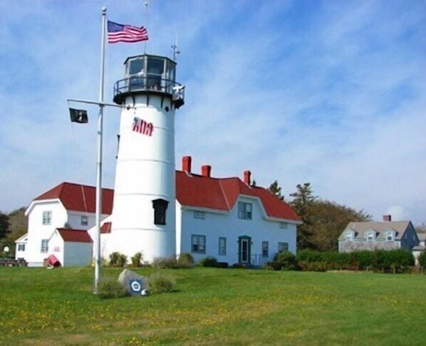 A lighthouse with a red roof and a white exterior, featuring a flagpole with an American flag. - Chatham-Walk to Town/Beach-Multi Family Friendly (Chatham)