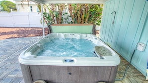 Un jacuzzi con revestimiento de madera, un panel de control y una manguera conectada a un enchufe.