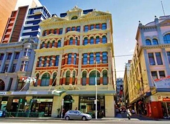 A multi-story building with a distinctive architectural style, featuring arched windows and a central entrance.