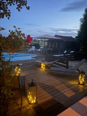 An outdoor deck with wooden flooring, lounge chairs, and lanterns. - Amazing views, private pool, only 8 mins walk to town with local amenities. (Lavardac)