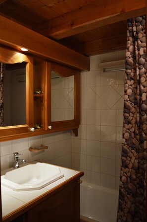 Baignoire, séchoir à cheveux, savon, papier de toilette