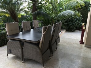 A dining area with a table and chairs, surrounded by lush greenery. - Luxury bright villa in Marbella Golden Mile with great sea and mountain views (marbella)