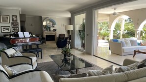 A spacious living room with a grand piano, comfortable seating, and a view of the outdoors. - Luxury bright villa in Marbella Golden Mile with great sea and mountain views (marbella)