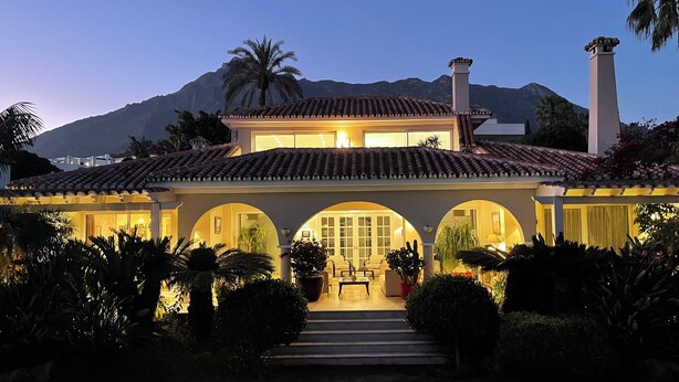 A two-story house with a tiled roof, arched entrance, and a balcony. - Luxury bright villa in Marbella Golden Mile with great sea and mountain views (marbella)