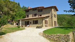 A stone building with a tiled roof, a stone staircase, and a paved driveway. - Typical house with large pool and lovely views (Cortona)
