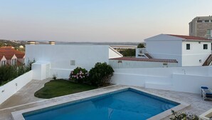 Una piscina con vistas a un cuerpo de agua y edificios al fondo.
