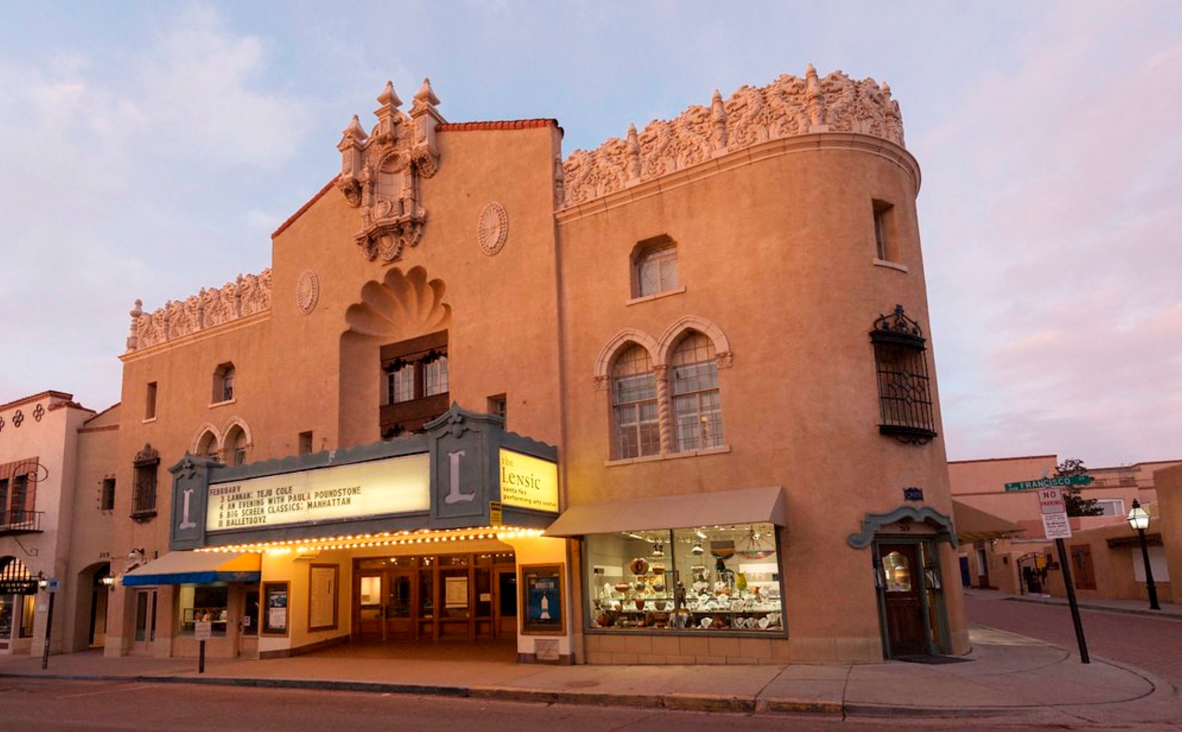A historic theater with ornate architecture and a marquee advertising performances.
