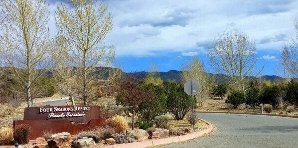 A sign for Four Seasons Resort in Rancho Encanto with a view of mountains and a clear sky. - SANTA FE ADOBE JEWEL (Santa Fe)