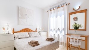 Ein ordentlich eingerichtetes Schlafzimmer mit Bett, Nachttischen, Schreibtisch und Stuhl.