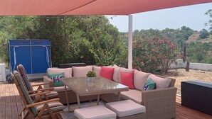 An outdoor patio with wicker furniture, a glass table, and a blue cabinet. - Large Villa with own Pool, 4 Bedrooms, Family Friendly, Shaded Pavillion. (Vale Covo, Loule)