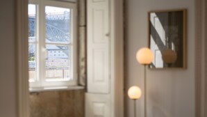 A room with a window, a door, a lamp, and a framed picture on the wall. - Feel Porto Ribeira Vintage Duplex (Oporto)