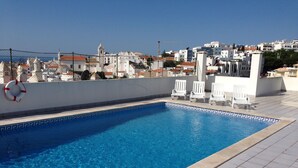 Une piscine rectangulaire à l’eau d’un bleu limpide, entourée d’une terrasse carrelée.