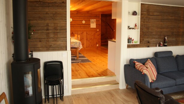 Una sala de estar acogedora con chimenea, un sofá y un comedor con mesa y sillas.