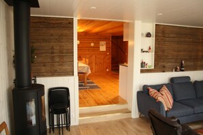 Una sala de estar acogedora con chimenea, un sofá y un comedor con mesa y sillas.