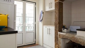 A kitchen with white cabinets, a yellow container, and a tiled backsplash. - Apartment Baixa/Chiado view Castle (Lisboa)