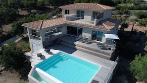 A two-story house with a swimming pool, outdoor seating, and a garden. - 10 minutes from the beach, luxury villa, ocean view, fiber-optic internet, heated pool, electrical outlet (Pinarellu)