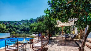 Un espace aménagé au bord de la piscine, comprenant une piscine, des chaises longues et une table avec des boissons.